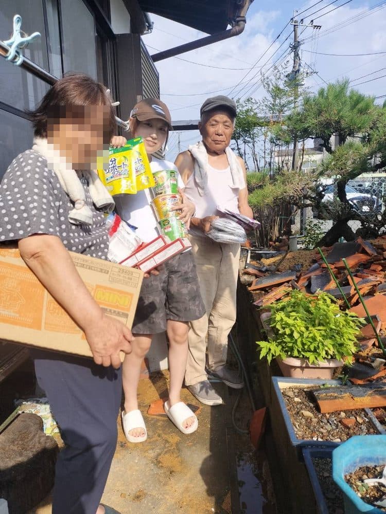 瓦礫の残る家の前で、食料品や日用品を受け取られたお二人